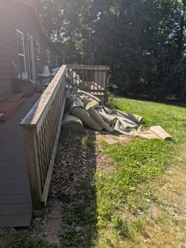 Carpet and pad pulled beside the deck at 4008 Myra Ct during rehab